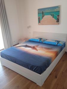 a bedroom with a bed with a painting of a pier at Ca' Giorgio in Cavallino-Treporti