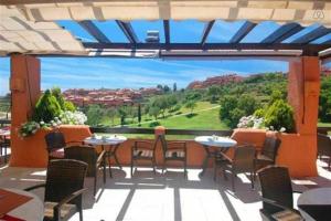 a patio with tables and chairs and a large window at Luxury apartment with sea views, golf, gym, spa, 7 pools in Ojén