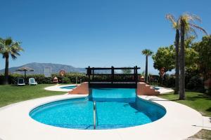 a pool at a resort with blue water at Luxury apartment with sea views, golf, gym, spa, 7 pools in Ojén
