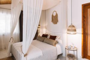 a bedroom with a white bed with a canopy at Anerada Cottages in Apsiou