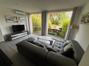 un salon avec un canapé et une grande fenêtre dans l'établissement Les Restanques Maison de la pinède 2 chambres, à Grimaud