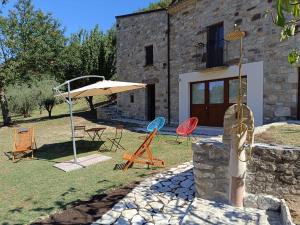 a group of chairs and an umbrella in front of a building at Il Melograno in Civita Campomarano