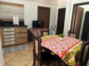 a dining room with a table with a colorful table cloth at Casa agradável in Indaial