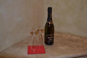 una bottiglia di vino seduta accanto a due bicchieri di vino di Dipendenza Hotel Galileo a Roma