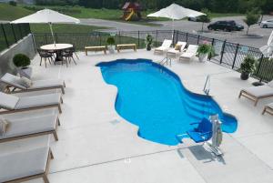 einen Pool auf einer Terrasse mit Stühlen und einem Tisch in der Unterkunft Stonecrest 717, 2bd Apt I Free Parking I Pool in New Albany