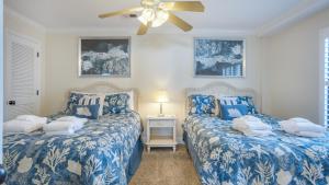 two beds in a room with blue and white covers at Oceanfront, Luxury Getaway, Bikes in Hilton Head Island +29 photos