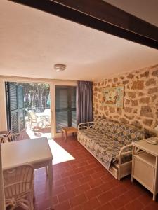 a bedroom with a bed in a room with a table at Condominio Dunelba in Marina di Campo