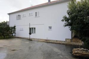 a white building with a parking lot in front of it at Guest house Renata 2 in Zadar +3 photos