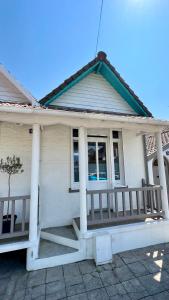 a white house with a porch and a window at Petite maison de charme in Le Touquet-Paris-Plage