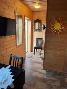 una sala de estar con un televisor y una mesa en Hyggelig lite bosted ved sjøen, nær sentrum i Valnesfjord, en Stokkland