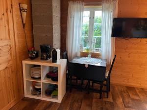Un comedor con una mesa y una ventana. en Hyggelig lite bosted ved sjøen, nær sentrum i Valnesfjord, en Stokkland