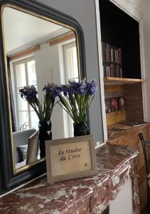 a mirror with vases with purple flowers on a table at L'Entre-Temps, Le Lys et L Iris in Saint-Aignan +15 photos