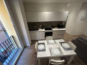 a small kitchen with a white table and chairs at Ariosti 3 - Piazza Maggiore in Bologna