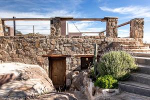 ビージャ・クーラ・ブロチェロにあるCueva de lujo con rio de montaña Casa cuevaの古石造りの建物(ドア、階段付)