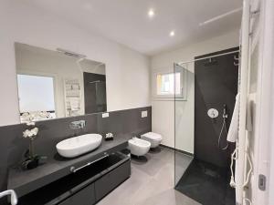 a bathroom with a sink and a toilet and a mirror at Ariosti 3 - Piazza Maggiore in Bologna