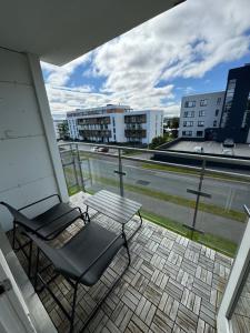 a patio with a table and chairs on a balcony at Comfy flat in Kópavogur in Reykjavík