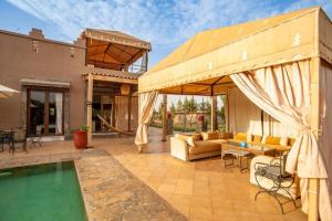 an outdoor patio with a pool and a pavilion at Villa Kenza in Tahannout