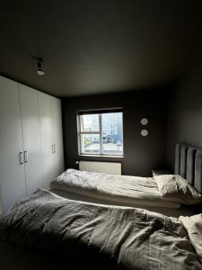 a bedroom with two beds and a window at Comfy flat in Kópavogur in Reykjavík