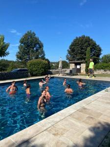 グラマにあるDomaine de Montantyのプールで泳いでいる人々のグループ