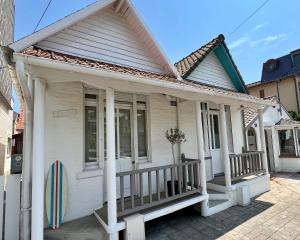 a white house with a porch with columns at Petite maison de charme in Le Touquet-Paris-Plage