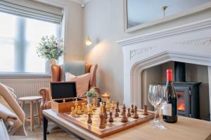 a living room with a chess board and wine glasses at Danes Cottage - Luxury Peak District Retreat in Chapel en le Frith