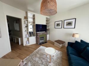 ブローニュ・ビヤンクールにあるMagnifique appartement entièrement rénovéの青いソファと暖炉のあるリビングルーム