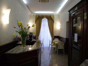 a room with a kitchen with a vase of flowers on a counter at Dipendenza Hotel Galileo in Rome