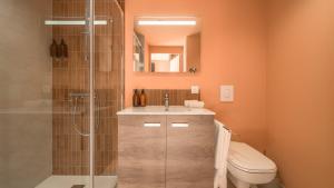 a bathroom with a toilet and a sink and a shower at Domaine Carrel & Senger in Jongieux