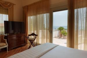 una camera da letto con un letto, una televisione e un balcone di VILLA ELENA a Moniga