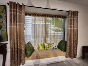 a window seat with pillows in front of a window at Aquavilla vedic village in Sikarpur +37 photos