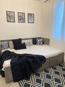 a bedroom with a large bed with black and white pillows at Nouveau CDG Parc d'expo de Villepinte in Aulnay-sous-Bois