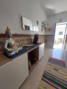 a living room with a couch and a statue on a counter at Paraíso da Aldeia in São Bartolomeu de Messines