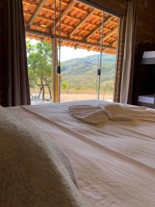 a bed in a room with a view of a mountain at pousada solar da canastra in Delfinópolis