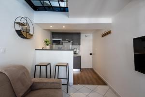 a living room with a couch and a kitchen at Studio Duplex in Montargis
