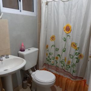 baño con aseo y cortina de ducha con girasoles en Verdes montañas, en Villa Nueva