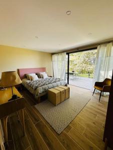 a bedroom with a bed and a large window at Chapelle Blóm in Nougaroulet