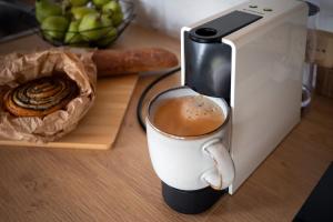 a coffee maker with a cup of coffee on a counter at Forrest Guest House in Ķesterciems