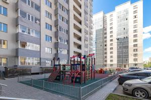 a playground in front of a building with tall buildings at Уютная кв в ЖК Комсомольский in Taldykolʼ