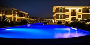 a blue swimming pool in front of a house at night at السخنة هيلز مدينة الجلالة Sokhna Hills Al Galala City Family only in Ain Sokhna