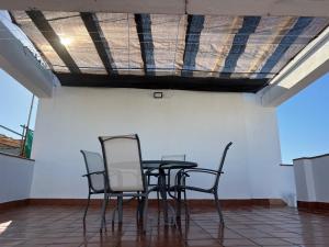 a table and chairs in a room with a ceiling at Seaside Paradise Mazagon in Mazagón +5 photos
