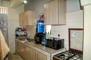 a kitchen with a counter top with a microwave and a stove at Zuri homes in Mombasa