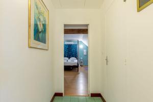 a hallway leading to a bedroom with a bed at L'Ozormo - Climatisée - Maison - Jardin in Amboise