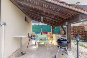a patio with a table and chairs and a grill at L'Ozormo - Climatisée - Maison - Jardin in Amboise +24 photos