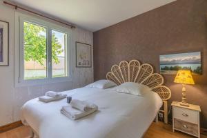 a bedroom with a large white bed with towels on it at L'Ozormo - Climatisée - Maison - Jardin in Amboise