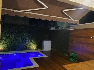an indoor pool with purple lights in a room at Casa em Condomínio com Piscina Privativa in Juquei