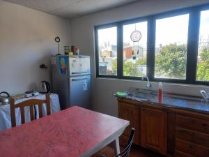 a kitchen with a refrigerator and a table and some windows at Amplio monoambiente in Paraná +4 photos