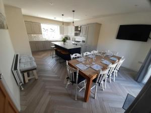 ein Esstisch mit Stühlen und eine Küche in der Unterkunft Rose Cottage Bushmills in Bushmills
