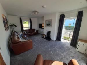 ein Wohnzimmer mit Ledersofas und einem TV in der Unterkunft Rose Cottage Bushmills in Bushmills