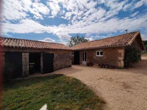 a large stone house with a large driveway at La bergerie de Genouse in Marnay