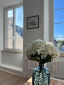 a blue vase with white flowers in a room at Appartement Richard Merrill 2 personnes en plein centre in Sainte-Mère-Église